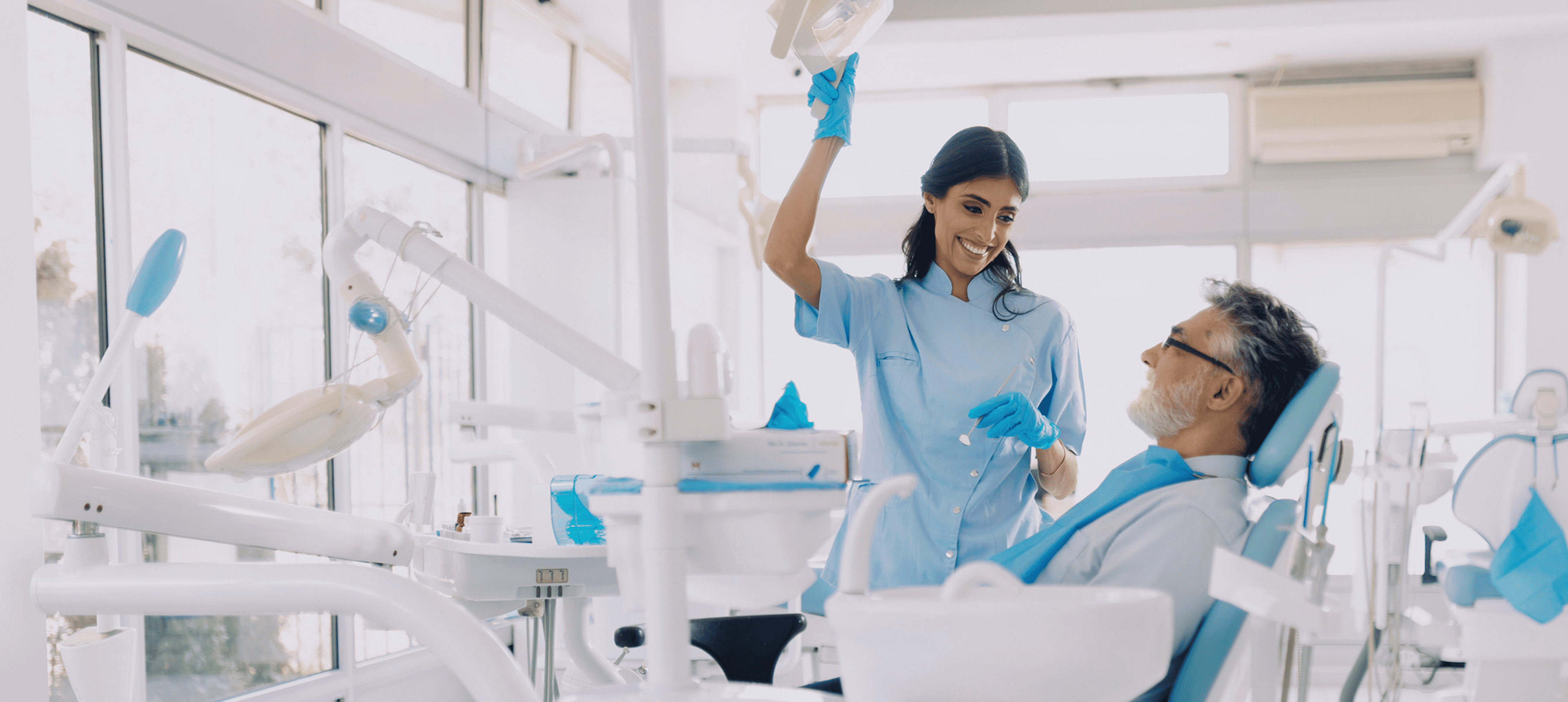 Patient in dental chair, dentist assisting