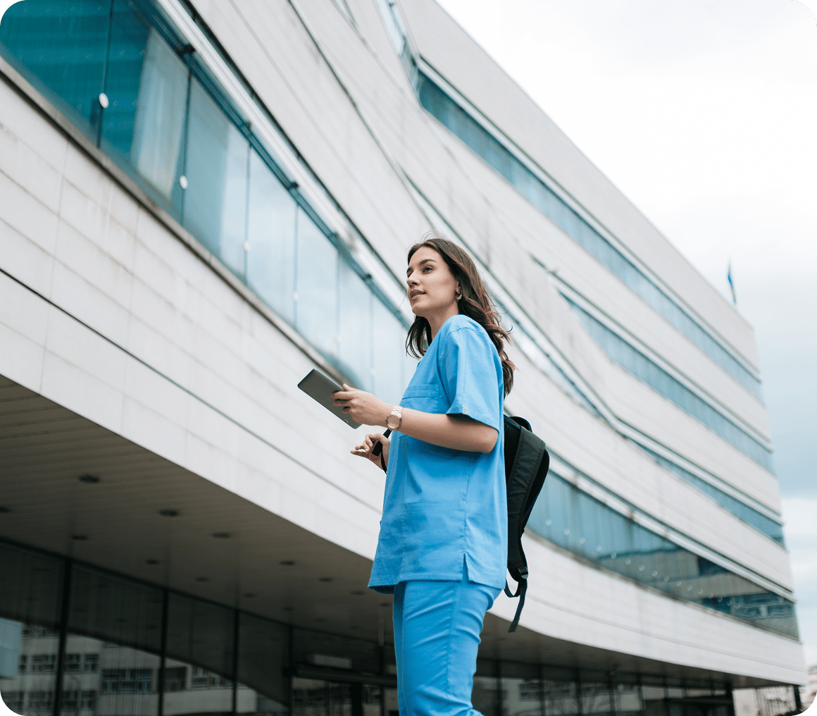 Healthcare worker with tablet near hospital