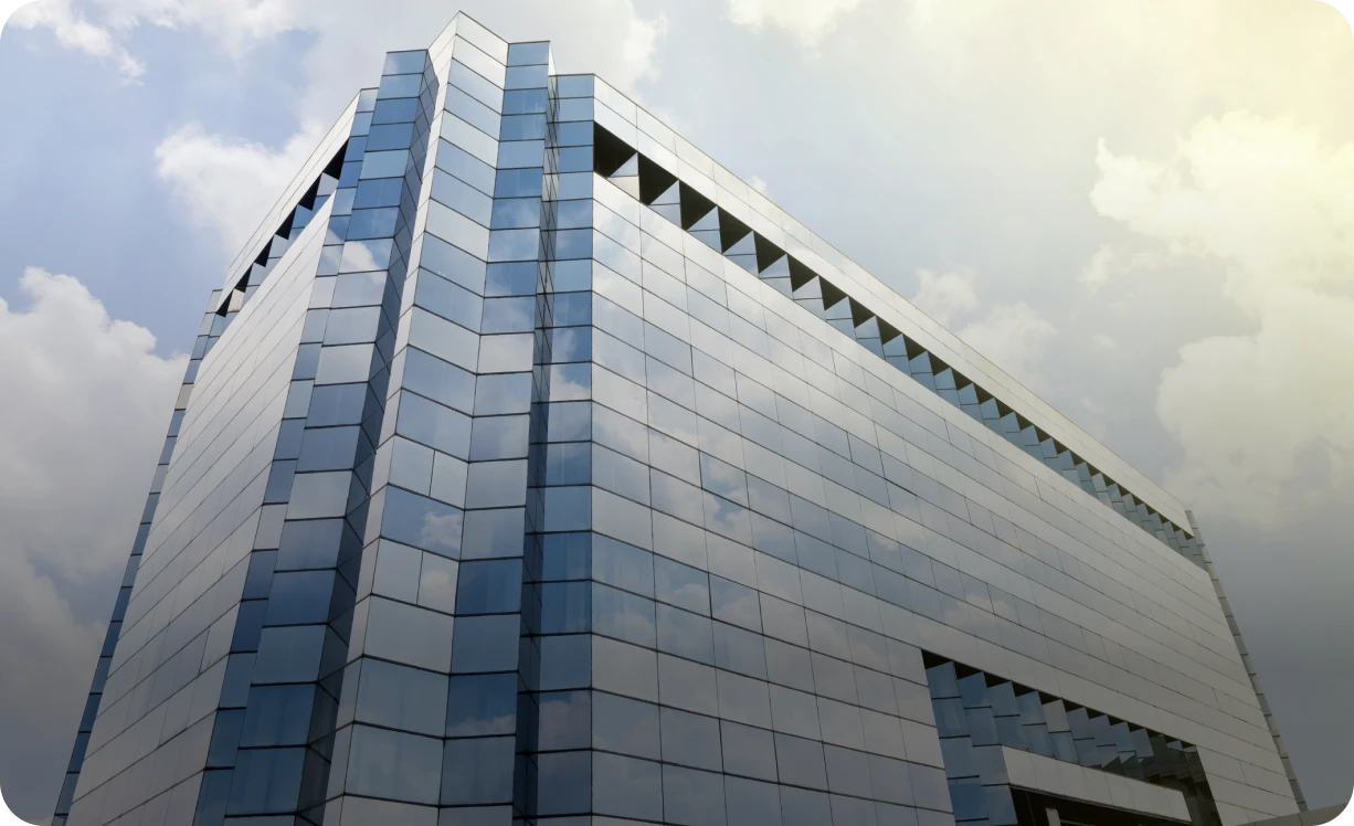 Modern glass building against cloudy sky